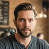Garrett Ashworth, Newswax Awakening Correspondent, holding coffee cup in Austin cafe