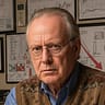 Economist Murray Belden reviews 2025 economic predictions in home office with charts